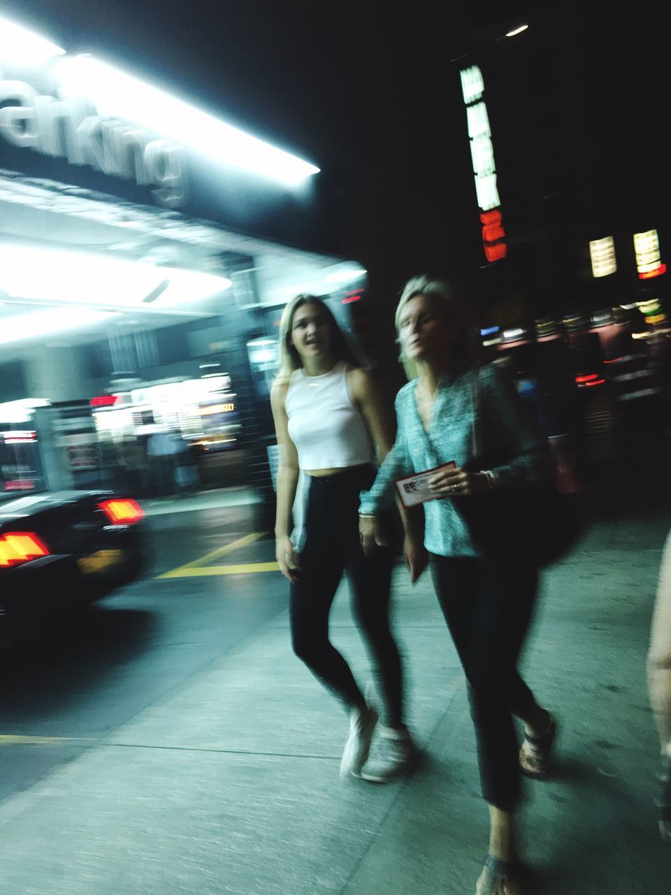 blurred motion, motion, on the move, transportation, walking, full length, night, street, mode of transport, city, illuminated, public transportation, city life, road, speed, land vehicle, car, lifestyles, travel, casual clothing, young women, outdoors, subway station, footpath, person, well-dressed