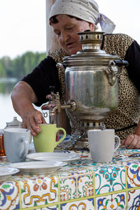 Midsection of woman holding coffee on table