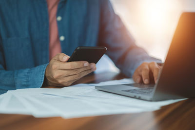 Midsection of woman using mobile phone