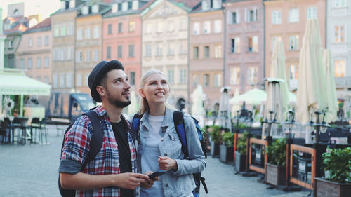 Smiling young man using mobile phone in city