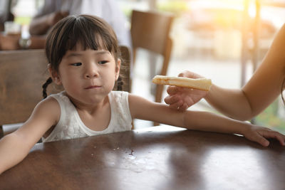 Portrait of cute girl having food at home