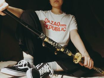 Midsection of man holding guitar