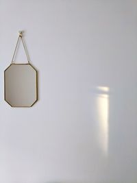 Close-up of electric lamp hanging on wall at home