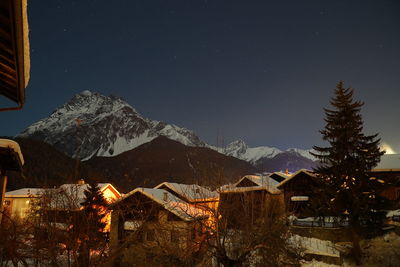 Illuminated buildings against sky at night during winter