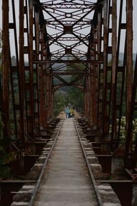 Rear view of people walking on bridge