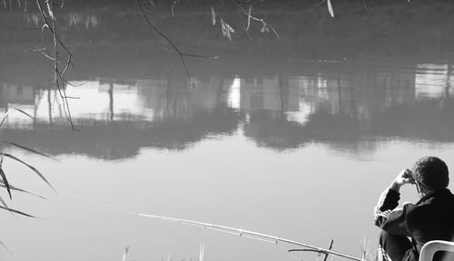 Rear view of people standing by lake