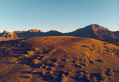 Scenic view of desert against clear blue sky