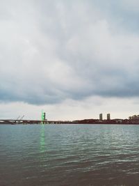 Lighthouse by sea against sky