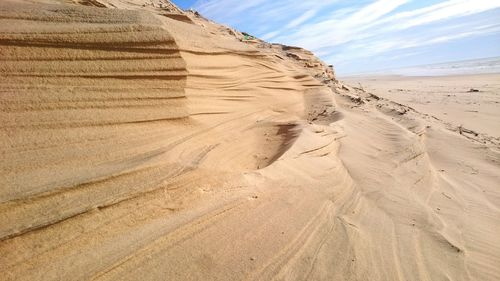 Scenic view of desert against cloudy sky