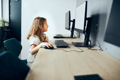 Child learning to use technology in classroom at primary school. student using computer on class