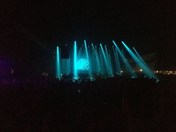 Firework display at music concert against sky at night