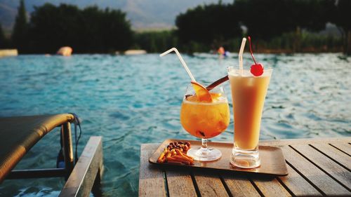 Close-up of beer in glass against sea