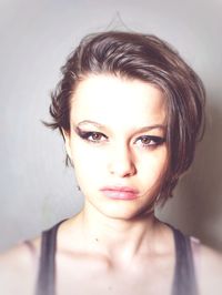 Close-up portrait of girl with make-up against wall