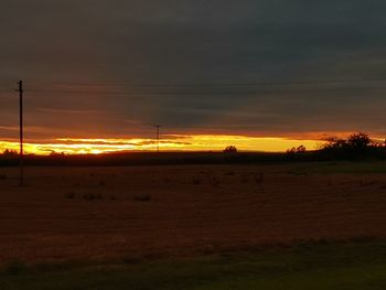 Scenic view of silhouette field against sky during sunset