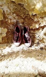 High angle view of shoes on stone wall