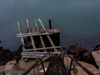 Damaged pier on rocks by sea
