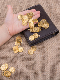 Close-up of hand holding gold colored coins