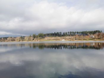 Scenic view of lake against sky in city