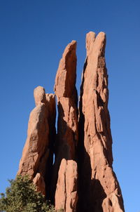 Low angle view of rock formation against clear blue sky