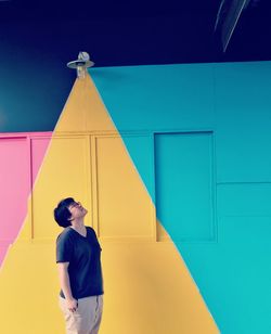 Full length of young man standing against building