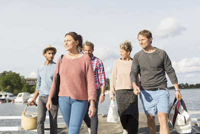 Group of friends walking together on pier