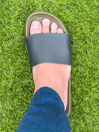 Low section of person wearing shoes on field