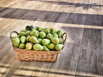 High angle view of pears in wicker basket on hardwood floor at home