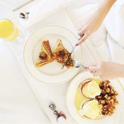 Cropped image of woman having breakfast on table at home