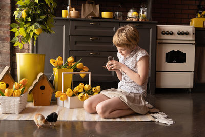 Girl sitting with chicks at home