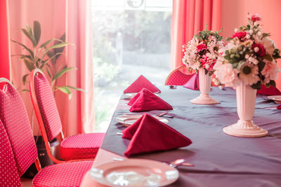 Photo of restaurant table with red napkins and flowers