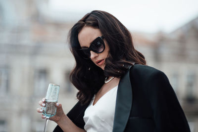 Portrait of woman with sunglasses standing outdoors