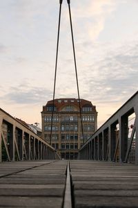 Footbridge against sky at sunset