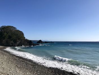 Scenic view of beach against clear blue sky