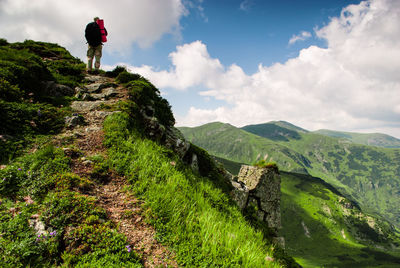 Full length of man standing on trail against sky