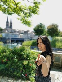 Young woman smiling while standing against plants