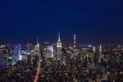 Illuminated cityscape against sky at night