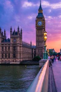 Westminster bridge over thames river against big ben during sunset