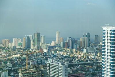 Aerial view of buildings in city against sky