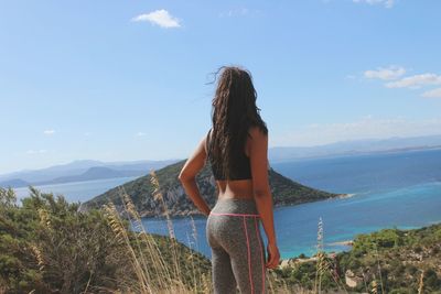 Woman standing on beach against sky