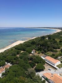 High angle view of houses by sea against clear sky