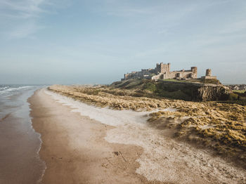 Scenic view of beach by sea against sky