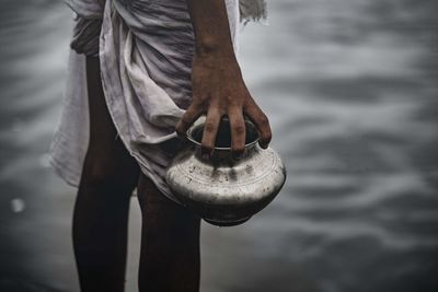 Low section of man holding water