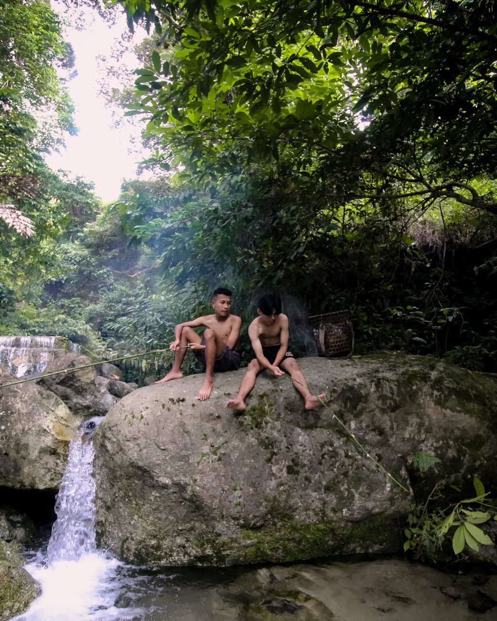 jungle, tree, waterfall, plant, water, nature, water feature, rock, leisure activity, togetherness, river, forest, adult, wilderness, rainforest, women, stream, two people, men, young adult, friendship, person, beauty in nature, trip, lifestyles, enjoyment, vacation, day, land, holiday, full length, body of water, female, outdoors, adventure, emotion, fun, bonding, happiness, child, positive emotion, motion, sitting, travel, scenics - nature, relaxation, childhood, activity, summer, clothing, environment, family, smiling, casual clothing, non-urban scene, swimwear