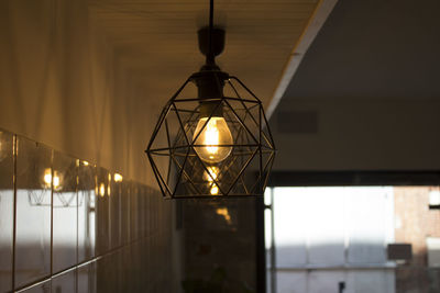 Illuminated pendant light hanging against wall