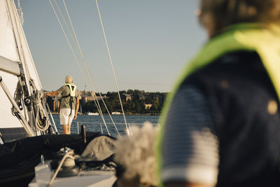 Rear view of senior man admiring sea against clear sky