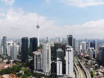 Modern buildings in city against cloudy sky