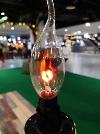 Close-up of illuminated light bulb on table at night