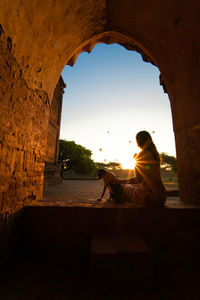 Side view of man sitting against the wall