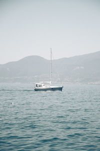 Sailboat sailing on sea against clear sky