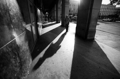 Shadow of woman walking on sidewalk